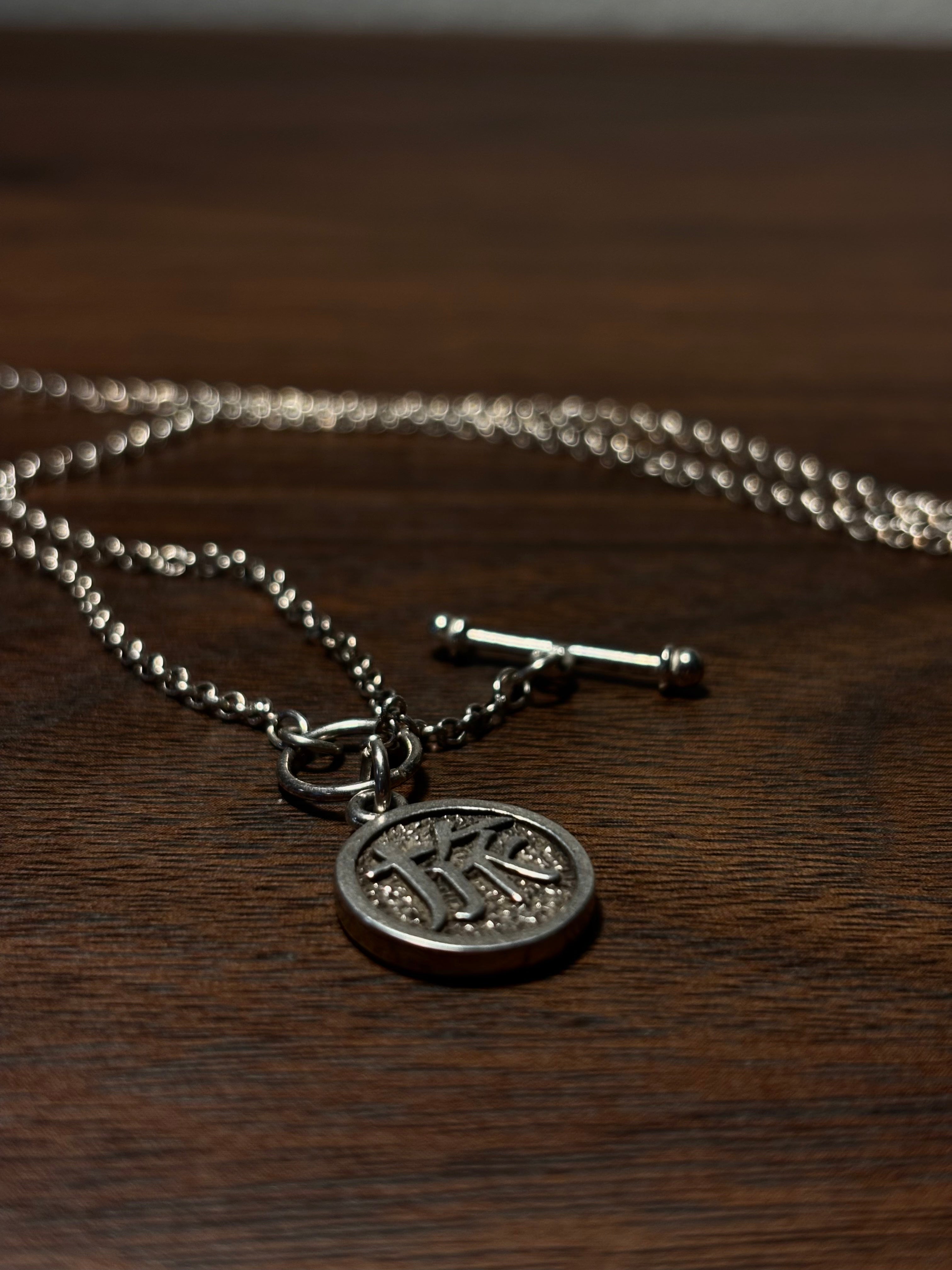 Silver necklace pendant with 'Journey' in Japanese script