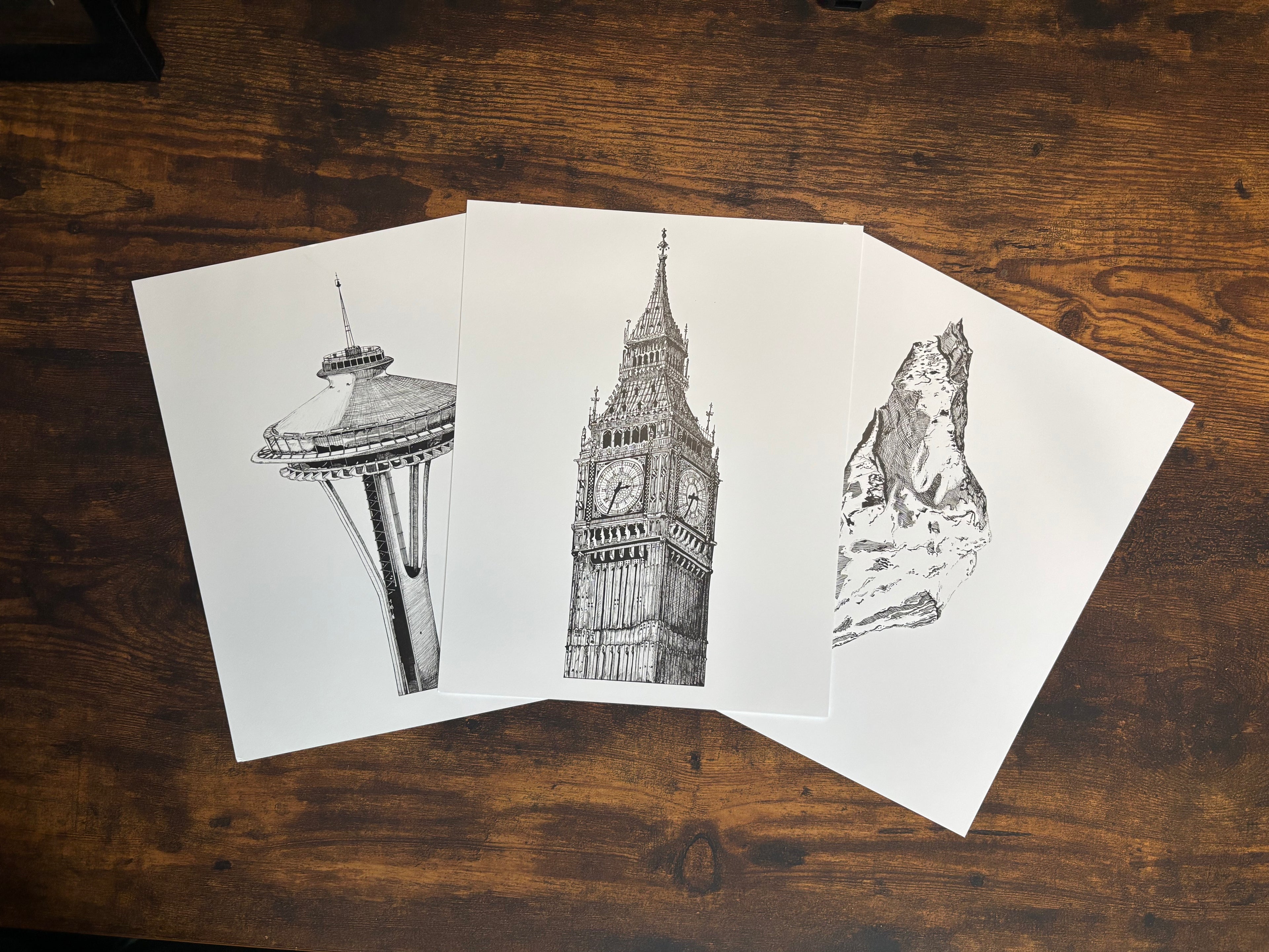 Collection of three art prints arranged in fan layout on workspace